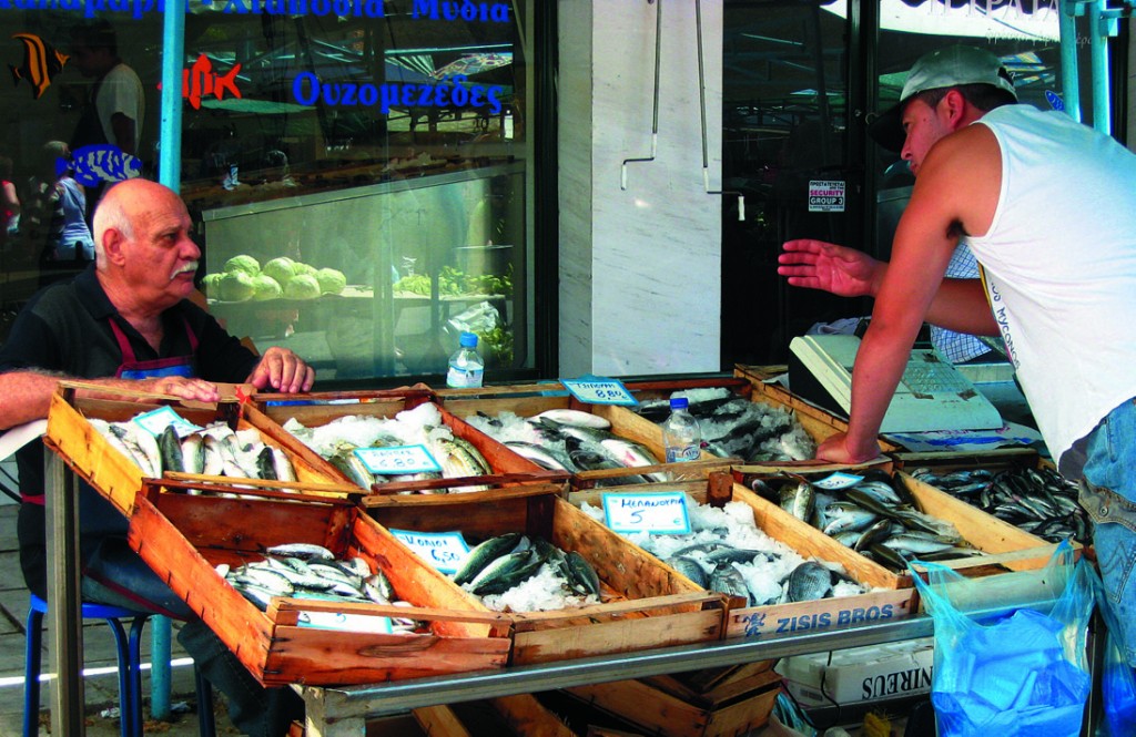 Greek men haggling over fish at the market